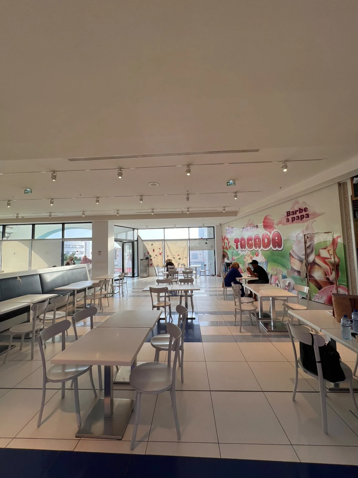 Un espace de pause avec des tables et des chaises à l’intérieur de Djerba Mall